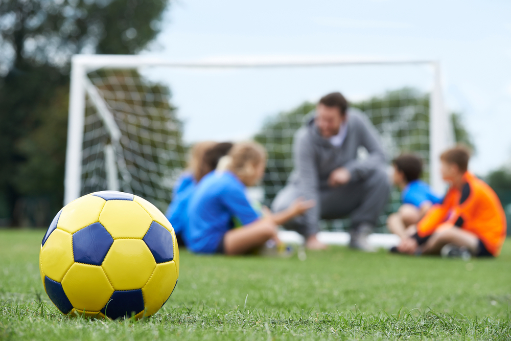 Coach And Team Discussing Soccer Tactics